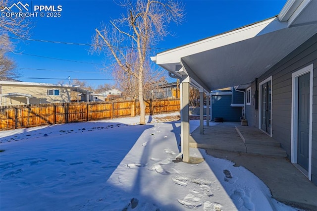 yard covered in snow with a patio area