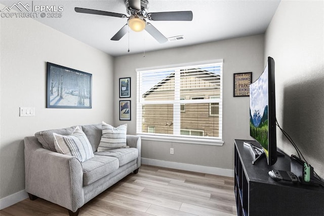 living room featuring ceiling fan and light hardwood / wood-style floors