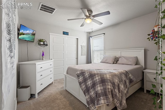 carpeted bedroom with ceiling fan and a closet