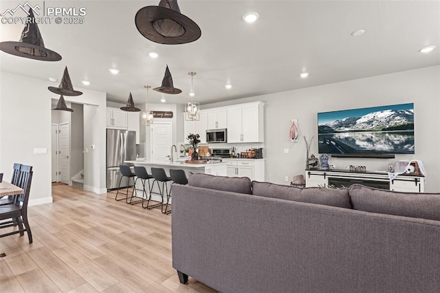 living room with sink and light hardwood / wood-style flooring