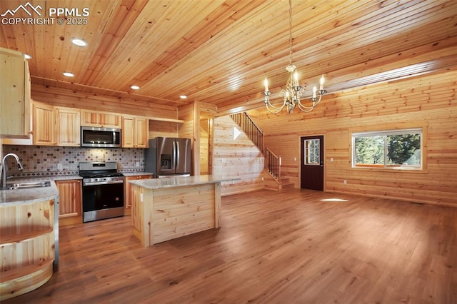 kitchen with sink, a center island, light brown cabinets, pendant lighting, and stainless steel appliances