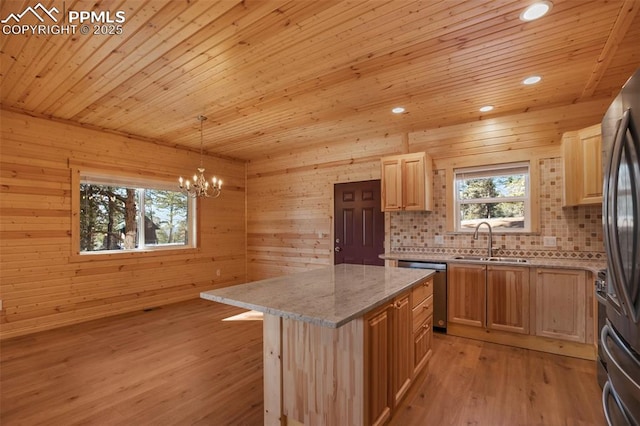 kitchen with sink, decorative light fixtures, light hardwood / wood-style floors, and a center island