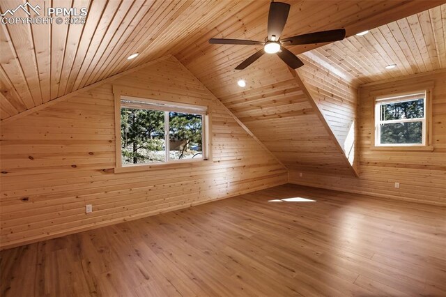 additional living space with wood ceiling, wood walls, vaulted ceiling, and hardwood / wood-style flooring