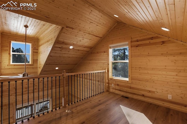 bonus room featuring lofted ceiling, wood ceiling, wooden walls, and hardwood / wood-style flooring