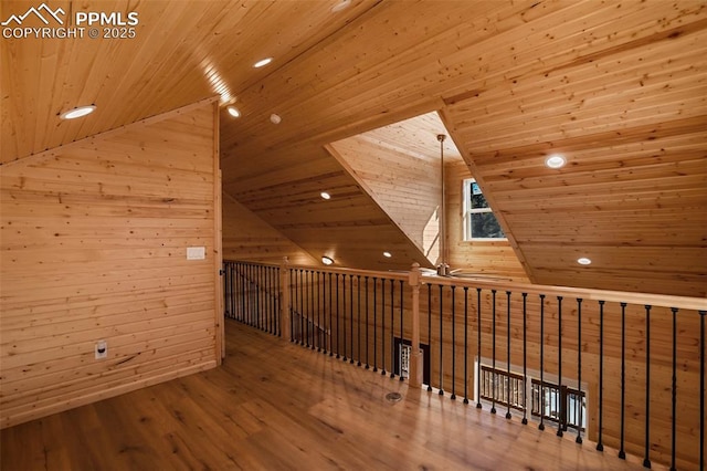 additional living space with lofted ceiling, hardwood / wood-style floors, wooden walls, and wooden ceiling