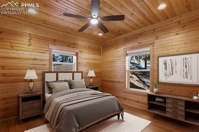 bedroom featuring ceiling fan, wood walls, light hardwood / wood-style flooring, and wooden ceiling