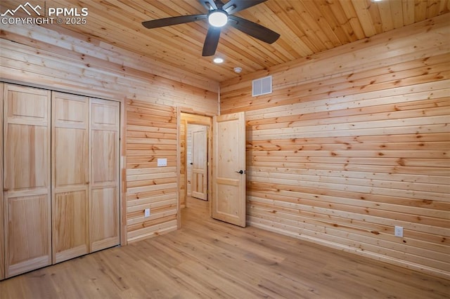 unfurnished bedroom with light hardwood / wood-style flooring, wooden ceiling, a closet, and ceiling fan