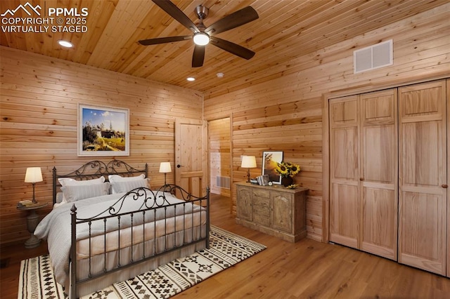 bedroom with wood ceiling, wood walls, and light wood-type flooring