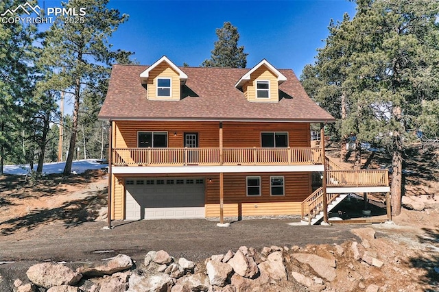 log-style house featuring a wooden deck and a garage