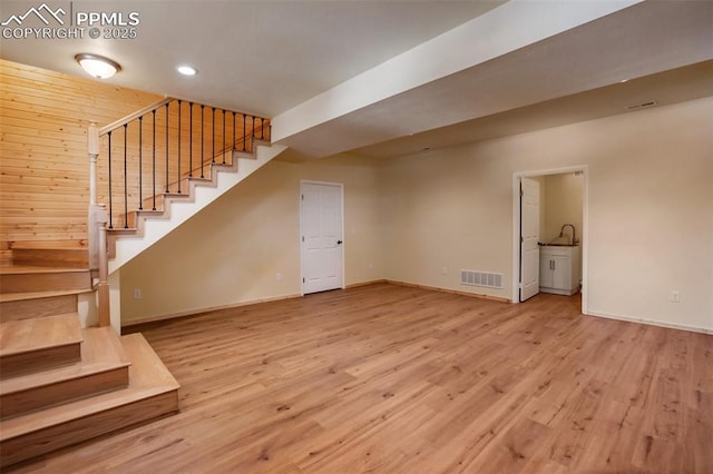 basement with light hardwood / wood-style floors