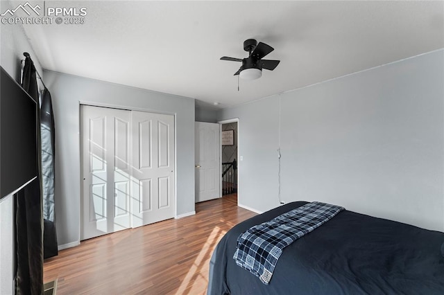 bedroom with hardwood / wood-style flooring, ceiling fan, and a closet