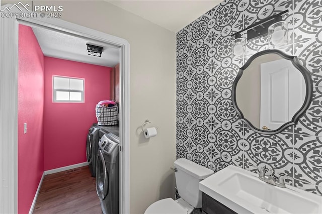 bathroom featuring vanity, hardwood / wood-style floors, washer and dryer, and toilet