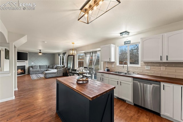 kitchen with white cabinetry, dishwasher, sink, and wooden counters