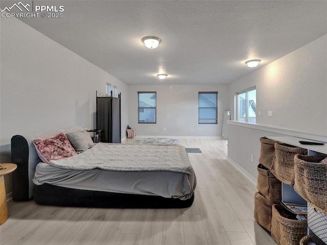 bedroom featuring a textured ceiling and light wood-type flooring