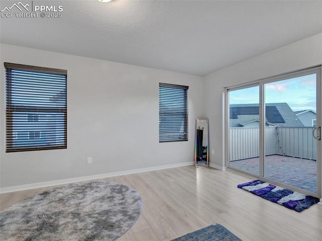 interior space with a textured ceiling and light hardwood / wood-style floors