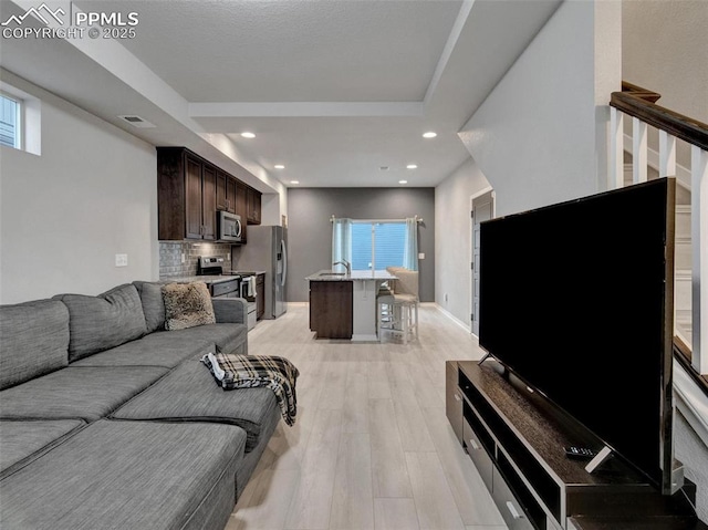 living room with sink and light hardwood / wood-style floors