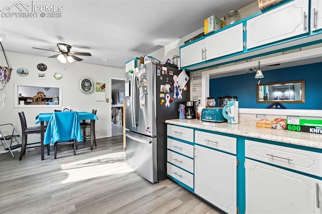 kitchen with white cabinetry, a textured ceiling, stainless steel fridge, ceiling fan, and light hardwood / wood-style floors