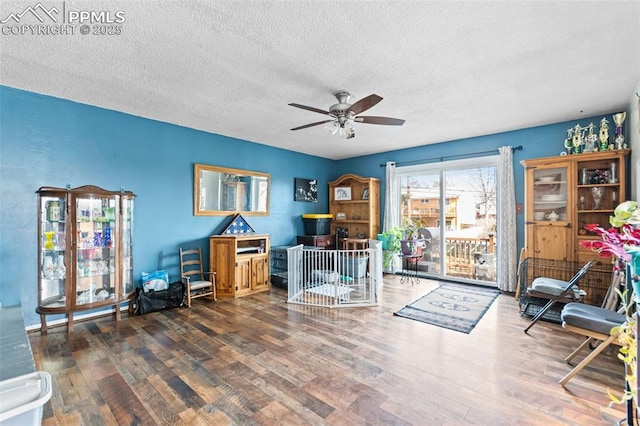 interior space with dark wood-type flooring, a textured ceiling, and ceiling fan