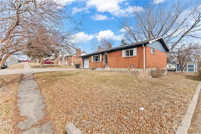 single story home with driveway, an attached garage, a front yard, and brick siding