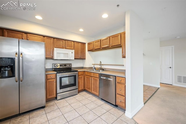 kitchen with light tile patterned flooring, stainless steel appliances, and sink