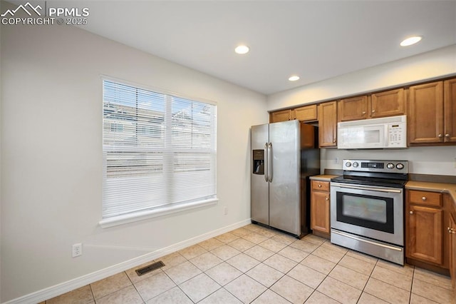 kitchen with stainless steel appliances and light tile patterned flooring