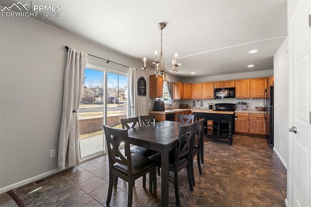 dining space featuring a chandelier and sink