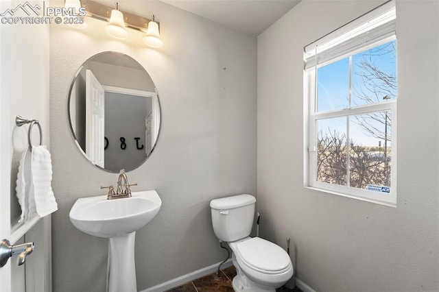 bathroom with tile patterned floors, toilet, and a wealth of natural light