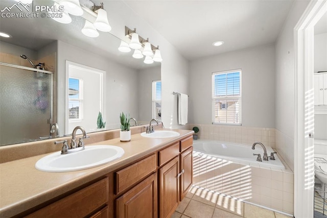 bathroom with tile patterned flooring, vanity, and separate shower and tub