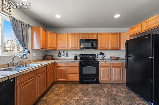 kitchen featuring tile countertops, sink, and black appliances