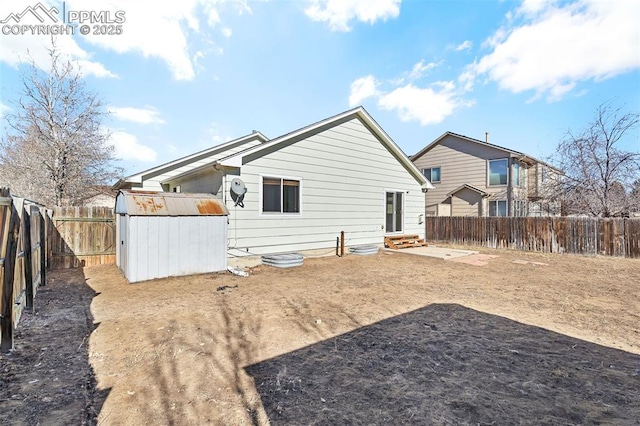 rear view of property featuring a storage shed