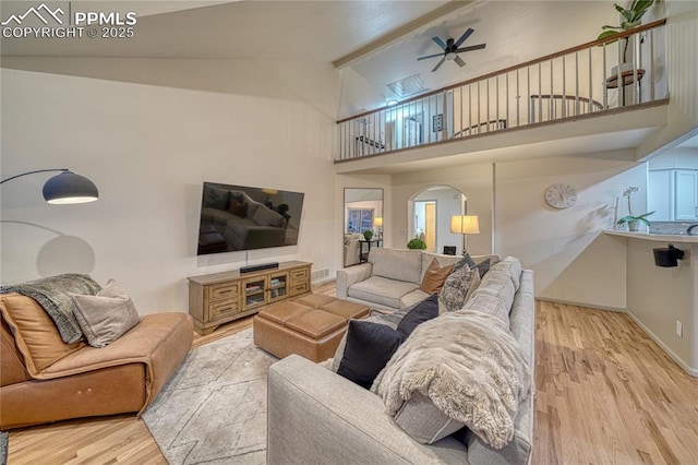 living room featuring light hardwood / wood-style flooring, high vaulted ceiling, and ceiling fan