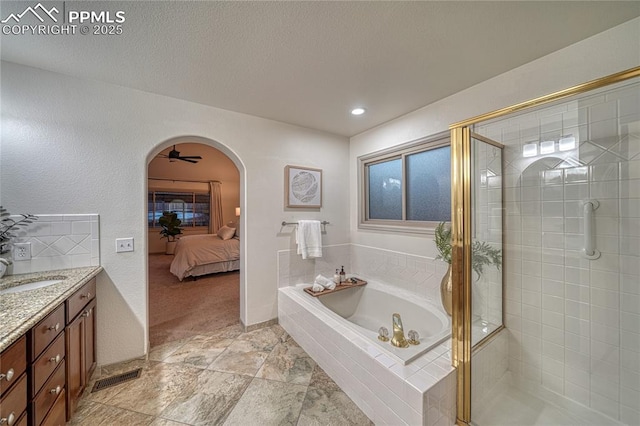 bathroom with vanity, shower with separate bathtub, and a textured ceiling