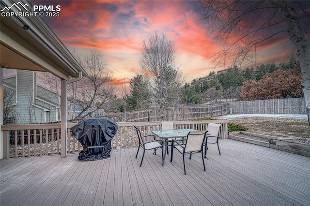 deck at dusk featuring grilling area