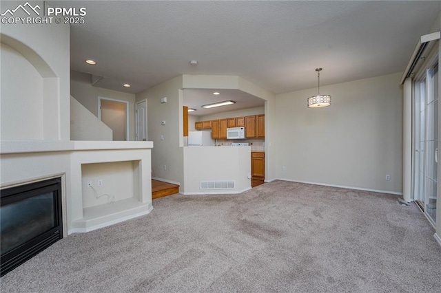 unfurnished living room featuring light colored carpet