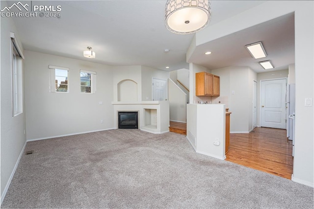 unfurnished living room featuring light colored carpet