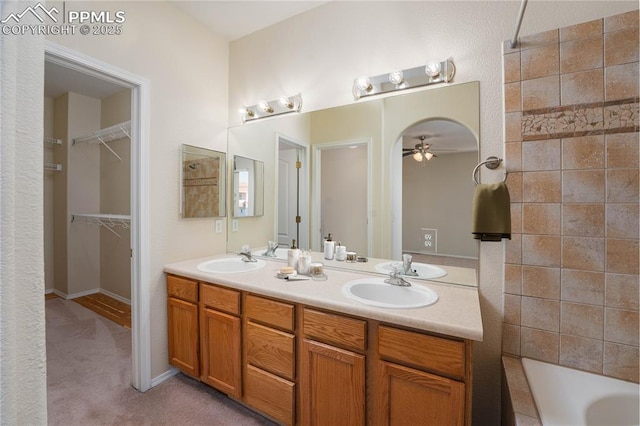 bathroom with vanity, a washtub, and ceiling fan