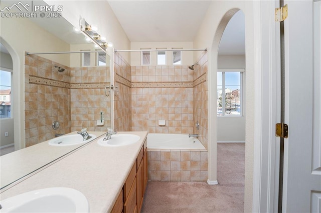 bathroom featuring tiled shower / bath combo and vanity