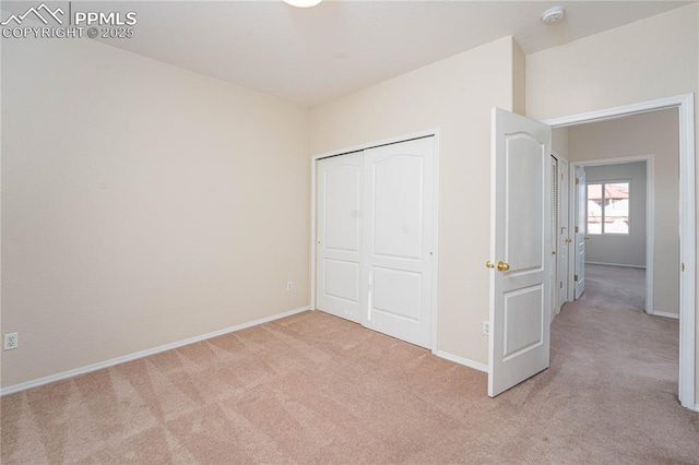 unfurnished bedroom featuring light colored carpet and a closet