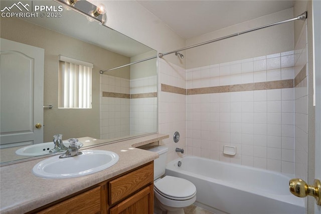 full bathroom featuring vanity, tiled shower / bath, and toilet