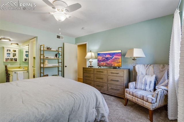 carpeted bedroom featuring visible vents, ceiling fan, and ensuite bathroom