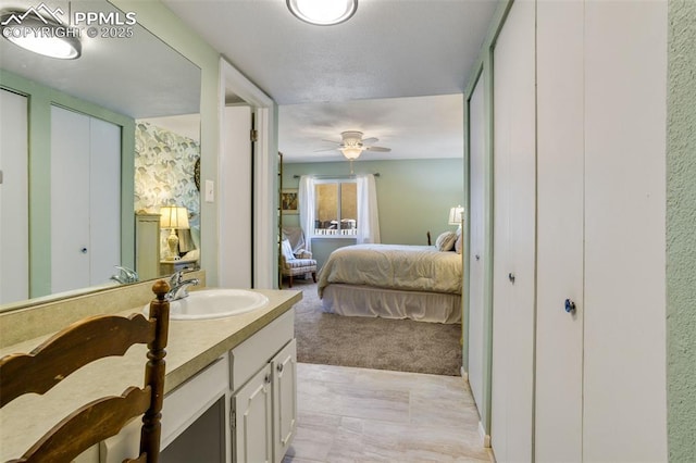 bedroom featuring a sink, light colored carpet, and multiple closets