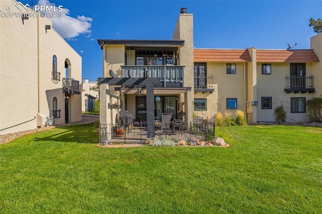 rear view of property featuring a patio area, a chimney, and a lawn