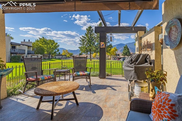 view of patio / terrace featuring fence and a mountain view