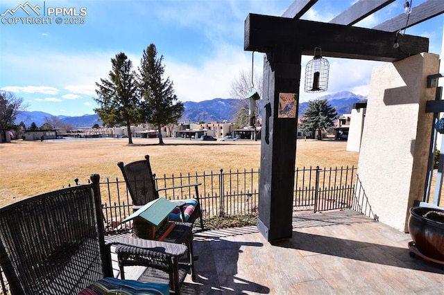 view of patio with a pergola, fence, and a mountain view