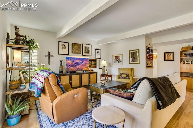 living area with beamed ceiling and wood finished floors