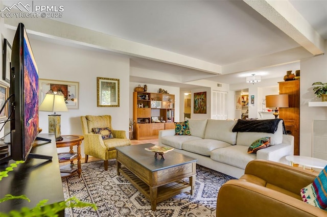 living room featuring beam ceiling and a notable chandelier