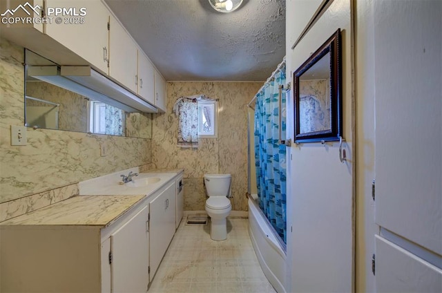 full bathroom with vanity, shower / bathtub combination with curtain, a textured ceiling, and toilet