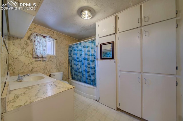 full bathroom featuring shower / bathtub combination with curtain, vanity, a textured ceiling, and toilet