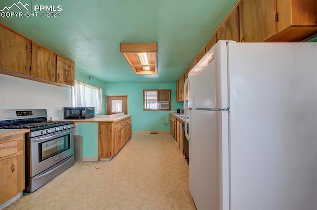 kitchen featuring white fridge and stainless steel gas range oven