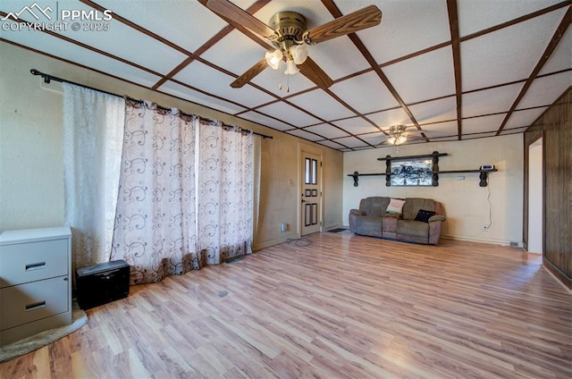 interior space featuring ceiling fan, coffered ceiling, and light wood-type flooring